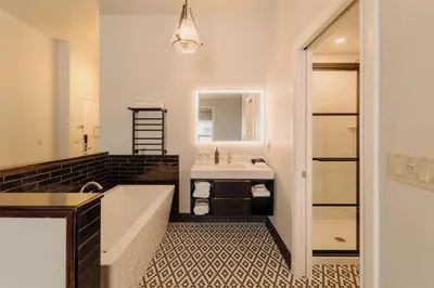a bathroom with a large tub and a sink at Mercer Hotel Downtown; BW Premier Collection in Stratford