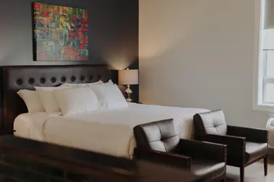 a bedroom with a large bed and two chairs at Mercer Hotel Downtown; BW Premier Collection in Stratford
