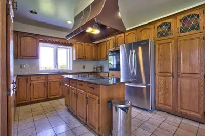 a kitchen with wooden cabinets and a stainless steel refrigerator at Grand Villa Estate in Burlington