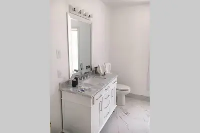 a white bathroom with a sink and a toilet at Grand Villa Estate in Burlington