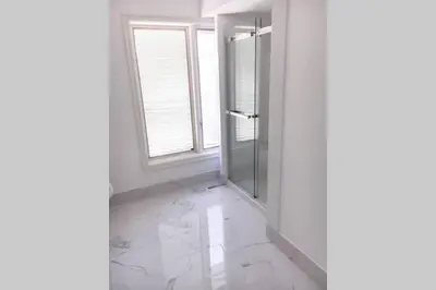 a bathroom with a glass shower and a window at Grand Villa Estate in Burlington