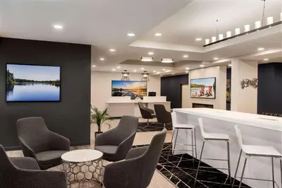 a waiting room with chairs and a table and a bar at Microtel Inn & Suites by Wyndham Aurora in Aurora