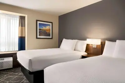 a hotel room with two beds and a window at Microtel Inn & Suites by Wyndham Aurora in Aurora