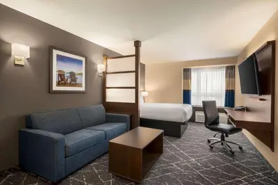 a hotel room with a couch and a bed at Microtel Inn & Suites by Wyndham Aurora in Aurora