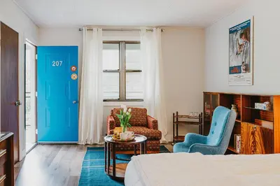 a room with a bed and a blue door at The Kent Motel in Niagara on the Lake