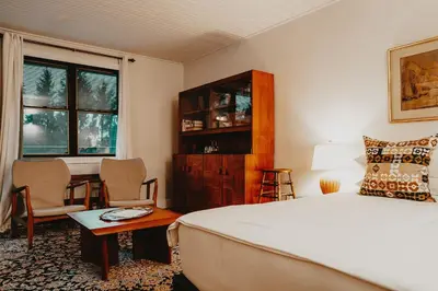a bedroom with a bed and a table and chairs at The Kent Motel in Niagara on the Lake