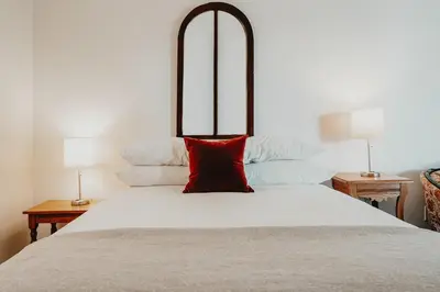 a bedroom with a large white bed with a red pillow at The Kent Motel in Niagara on the Lake