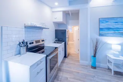 a white kitchen with a stove and a refrigerator at Boutique Suite #3 in Blue Mountains