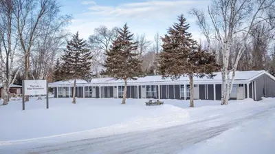 a building in the snow with trees in front of it at Boutique Suite #5 in Blue Mountains