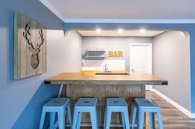 a kitchen with a bar with stools around it at 4 Bedroom Rustic Chalet in Blue Mountains