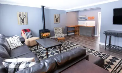 a living room with a leather couch and a fireplace at 4 Bedroom Rustic Chalet in Blue Mountains
