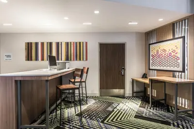 a bar in a room with chairs and a desk at Holiday Inn Express & Suites - Welland in Welland