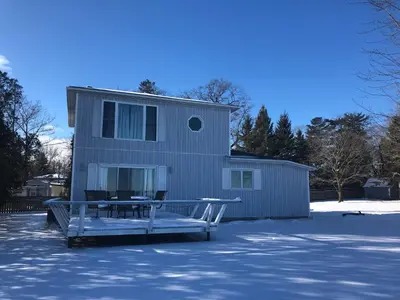 a house with a table in front of it at Entire waterfront cottage in carrying place in Carrying Place