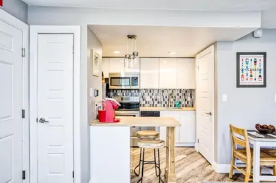 a kitchen with white cabinets and a table and chairs at Luxury Studio Getaway at Blue Mountains 80114 in Blue Mountains