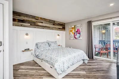 a bedroom with a bed with a wooden wall at Luxury Studio Getaway at Blue Mountains 80114 in Blue Mountains