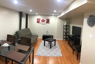 a living room with a couch and a tv at 3 Spacious Bedroom Basement Apartment in Richmond Hill in Richmond Hill