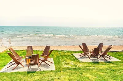 a group of chairs and a table on the beach at The Long Beach Resort - Beachfront Cottages & Townhouse Suites in Wainfleet