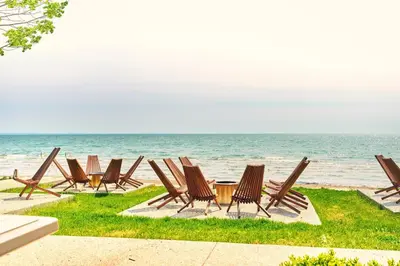 a row of chairs sitting on the beach at The Long Beach Resort - Beachfront Cottages & Townhouse Suites in Wainfleet