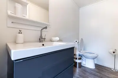 a bathroom with a sink and a toilet at The Long Beach Resort - Beachfront Cottages & Townhouse Suites in Wainfleet