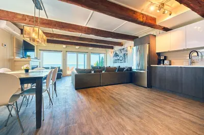 a kitchen and living room with a table and chairs at The Long Beach Resort - Beachfront Cottages & Townhouse Suites in Wainfleet