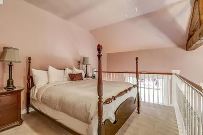 a bedroom with a large bed and a balcony at School House Bed and Breakfast C.1859 in Niagara on the Lake