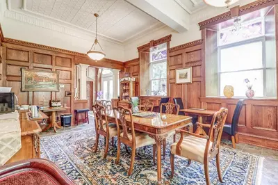 a dining room with wooden walls and a table and chairs at School House Bed and Breakfast C.1859 in Niagara on the Lake
