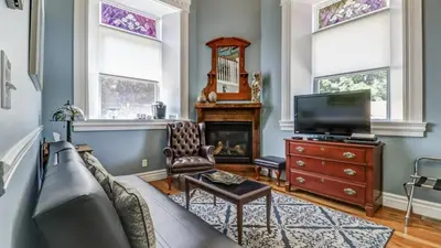 a living room with a couch and a tv at School House Bed and Breakfast C.1859 in Niagara on the Lake