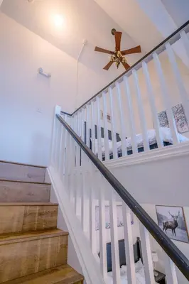 a white staircase with a ceiling fan and a stair case at Loft with a view of Blue - Free Wifi, Linens and Towels Included in Blue Mountains