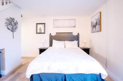 a bedroom with a large white bed with two night stands at Loft with a view of Blue - Free Wifi, Linens and Towels Included in Blue Mountains