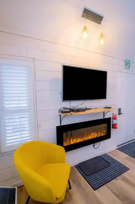 a living room with a yellow chair and a television at Loft with a view of Blue - Free Wifi, Linens and Towels Included in Blue Mountains