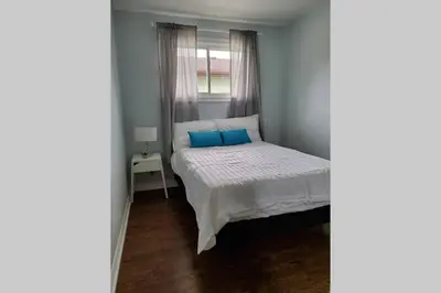 a small bedroom with a bed with blue pillows at Cottage with River Front & minutes away from Beach in Wasaga Beach