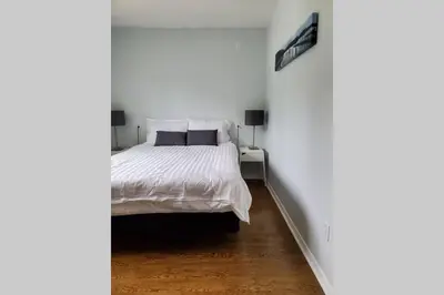 a bedroom with a white bed in a white room at Cottage with River Front & minutes away from Beach in Wasaga Beach