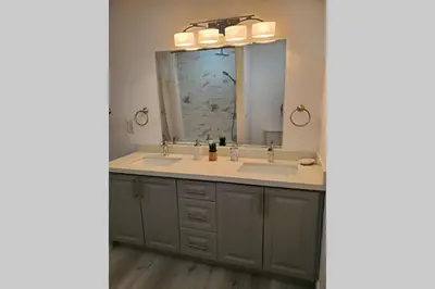 a bathroom with two sinks and a large mirror at Cottage with River Front & minutes away from Beach in Wasaga Beach