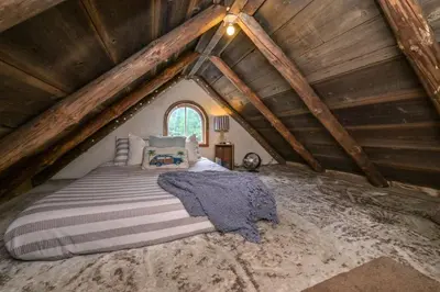 a bedroom with a bed in a attic at A rustic cabin in the woods in Orangeville