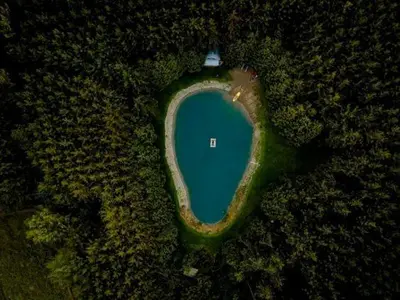 an aerial view of a blue lake in a field at A rustic cabin in the woods in Orangeville