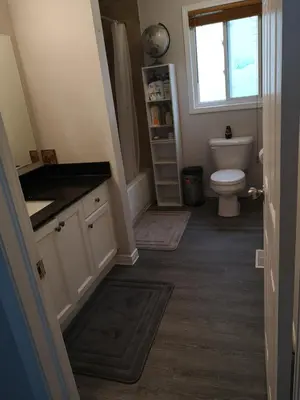 a bathroom with a toilet and a sink and a window at Comfortable room B in Kitchener