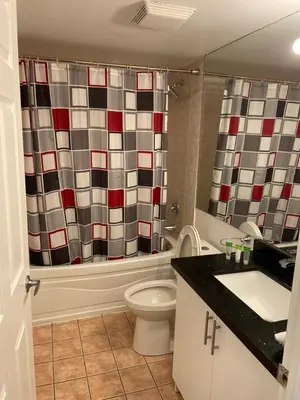a bathroom with a toilet and a shower curtain at PlanURstay in Mississauga