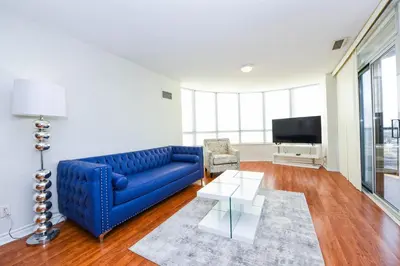 a living room with a blue couch and a tv at PlanURstay in Mississauga