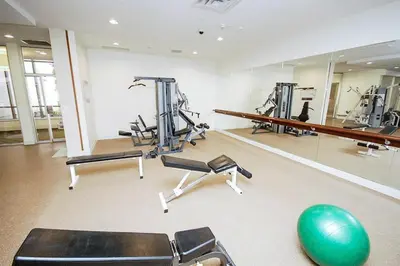 a gym with several tread machines and a green ball at PlanURstay in Mississauga