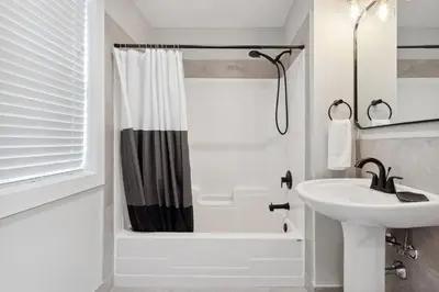 a white bathroom with a sink and a shower at 2 Bedroom Condo only steps to the Village! in Blue Mountains