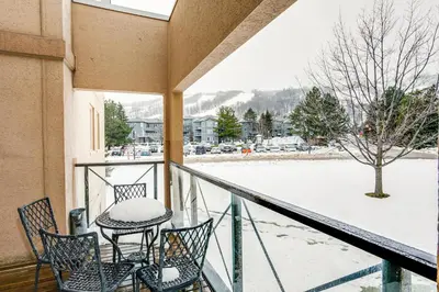 a balcony with a table and chairs in the snow at 3 Bedroom Mountain Walk Condo, Steps to Village in Blue Mountains