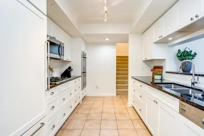 a kitchen with white cabinets and a sink at 3 Bedroom Mountain Walk Condo, Steps to Village in Blue Mountains