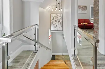 a staircase in a home with white walls and wood floors at ENTIRE 1 BEDROOM APARTMENT ACROSS FROM GOOGLE - br5 in Kitchener