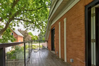 a balcony with a wooden deck next to a brick building at ENTIRE 1 BEDROOM APARTMENT ACROSS FROM GOOGLE - br5 in Kitchener