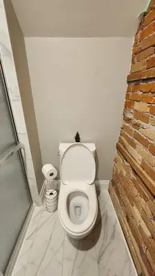 a bathroom with a toilet with a brick wall at ENTIRE 1 BEDROOM APARTMENT ACROSS FROM GOOGLE - br5 in Kitchener
