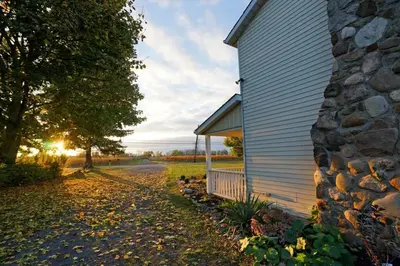 a building with a stone wall next to a street at Arrowstone Farmhouse in Historic Old Town in Niagara on the Lake