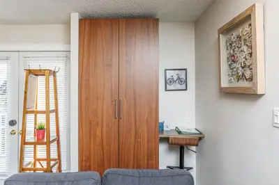 a living room with a wooden cabinet and a desk at Cozy Collingwood Retreat 80204 in Collingwood