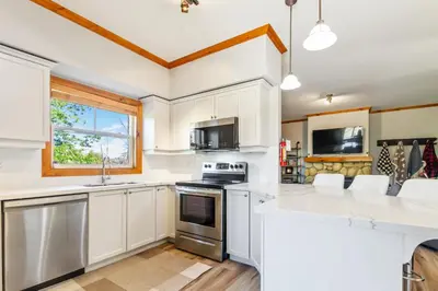 a kitchen with white cabinets and a stove top oven at Blue Mountain 3 bedroom Dream Chalet 81590 in Collingwood