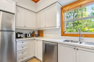 a kitchen with white cabinets and a sink and a window at Blue Mountain 3 bedroom Dream Chalet 81590 in Collingwood