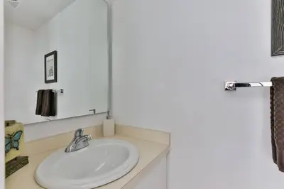 a bathroom with a white sink and a mirror at Two BD CN Tower and Lake Ontario View in Toronto